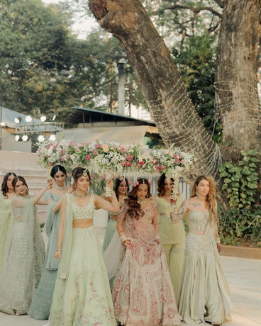Bridesmaids in pastel lehengas under a tree