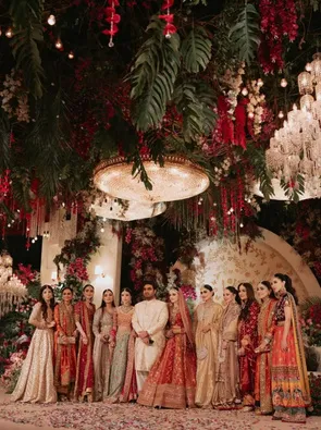 Wedding party gathered under a floral canopy